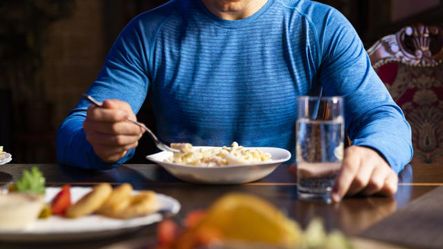 Close-up of athlete eating pasta dish 