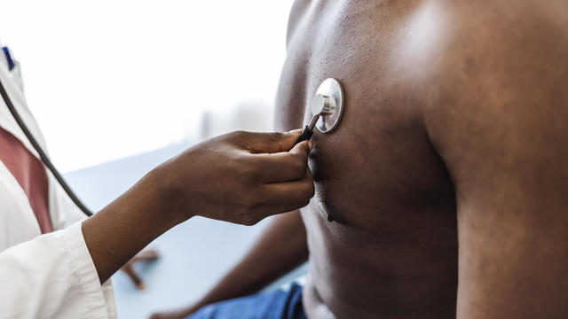 Female doctor listens to a patient's lungs during a medical exam 