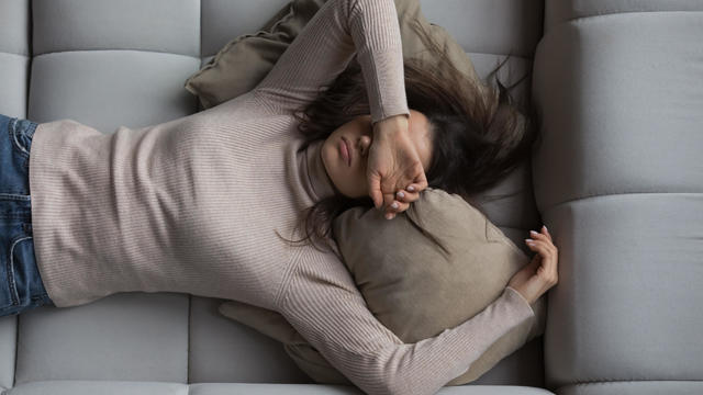 Peaceful girl lying on back on comfortable couch at home 