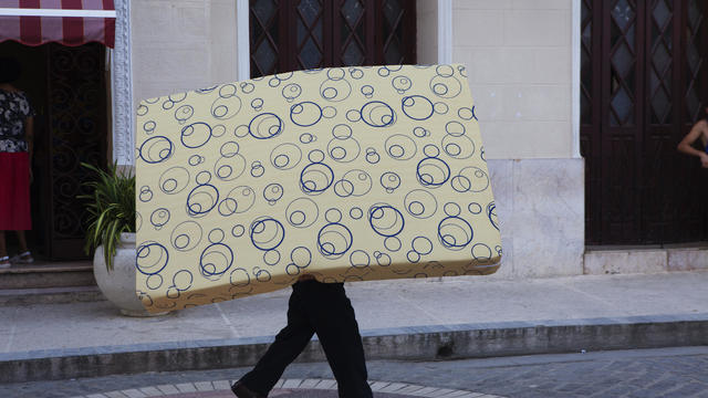 A man carrying a mattress 
